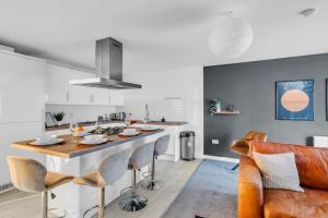 a kitchen and living room with a large kitchen island at Sleek City Living with Bicocca Stays in Aberdeen +12 photos