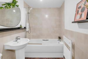 a white bathroom with a sink and a bath tub at Sleek City Living with Bicocca Stays in Aberdeen