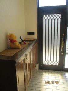 un osito de peluche sentado en un mostrador junto a una puerta en Private inn “Come! Akae House” - Vacation STAY 61227v, en Toyama