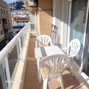 - Balcón con mesa blanca y sillas en apartamento llandells casa kiko, en Peñíscola