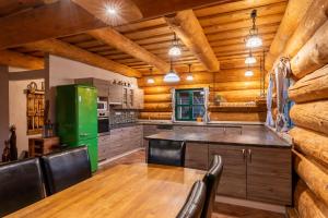 a kitchen with wooden walls and a green refrigerator at Srub Pohodář v Novohradských horách in Benešov nad Černou