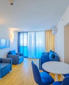 uma sala de estar com cadeiras azuis e uma mesa em Luxury PANORAMA sea view apartment & Central Batumi em Batumi