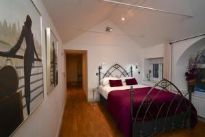 a bedroom with a bed with a purple bedspread at Tudor Lodge Bed & Breakfast in Manorbier