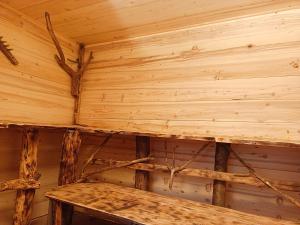 una cabaña de madera con un banco en la esquina en GÎTE REDROOSTER HOME - Chaleur et bien-être au pied des 7 Laux - 4 ch - 2 sdb - Parking en Theys