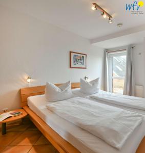1 cama blanca grande en una habitación con ventana en Ferienpark Seedorf Haus Granitz - Ferienwohnung 2, en Sellin