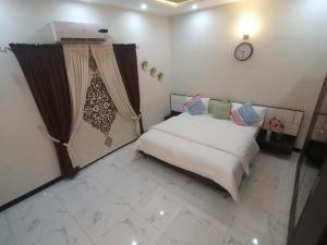 a bedroom with a bed and a clock on the wall at Edge of Islamabad Entrance in Islamabad