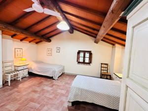 a bedroom with two beds and a wooden ceiling at Mansarda Molenda in Città di Castello