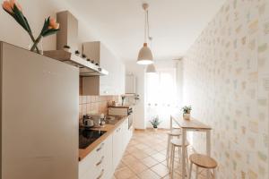 cocina con armarios blancos, mesa y sillas en CR32 TOURIST ACCOMODATION, en Civitavecchia