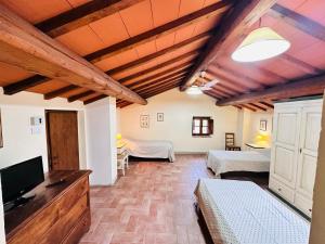 a room with two beds and a flat screen tv at Mansarda Molenda in Città di Castello
