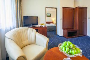 uma sala de estar com uma cadeira e uma mesa com uma taça de fruta em Czarny Potok-klimatyczny hotel z basenem, jaccuzi i saunami em Zakopane