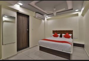 a bedroom with a bed with red pillows at HOTEL SUNWAY in Ahmedabad
