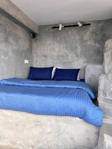 Cette chambre comprend un grand lit avec des oreillers bleus. dans l'établissement Three Creeks Matale, à Matale