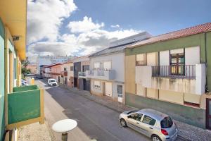 ein Auto, das an der Seite einer Straße mit Gebäuden parkt in der Unterkunft A O - Augusta in Peniche