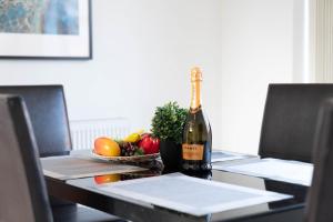butelkę szampana i miskę owoców na stole w obiekcie Detached 3 Bedroom House - Gaerden - Parking - Top Rated - Netflix - Wifi - 98C w Birmingham