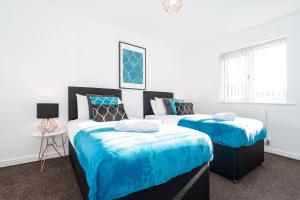 1 Schlafzimmer mit 2 Betten und blauer Bettwäsche in der Unterkunft Detached 3 Bedroom House - Gaerden - Parking - Top Rated - Netflix - Wifi - 98C in Birmingham
