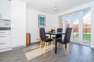 a dining room with a black table and chairs at Detached 3 Bedroom House - Gaerden - Parking - Top Rated - Netflix - Wifi - 98C in Birmingham
