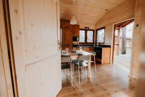 a kitchen and dining room with a table and chairs at WYPOCZYWANKO w BORSKU domek 24 in Borsk +32 photos