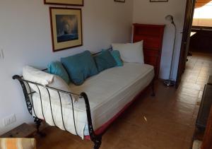 a bed with blue pillows on it in a room at STELLA HOUSE in Porto Santo Stefano