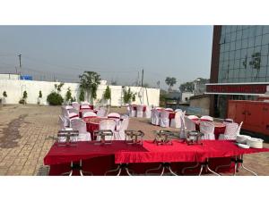 a group of tables and chairs with red table cloth at Hotel Nalanda Inn Bihar in Nalanda