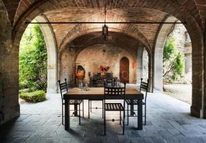 a table and chairs under an archway in a house at Castello Borgia in Passignano sul Trasimeno