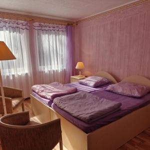 two beds in a bedroom with purple sheets at Ośrodek Wypoczynkowy Puszczyk Domek Akacjowy- Apartament -Willa in Sieraków