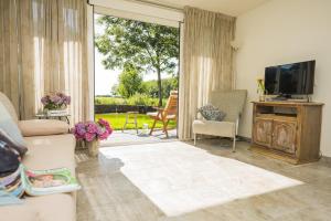 a living room with a couch and a television at B&B Louisehoeve in Linschoten