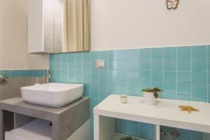 a bathroom with a white sink and blue tiles at BarbyB B&B in Salerno