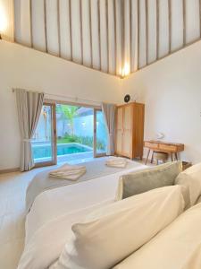 a bedroom with a large bed and a pool at Mimpi Villa - Gili Air in Gili Air