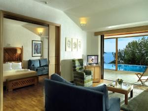 una sala de estar con cama y una habitación con vistas. en Porto Elounda Golf & Spa Resort, Six Senses Spa, en Elounda