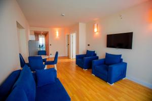 sala de estar con sillas azules y TV de pantalla plana en Welcome To Batumi, en Batumi