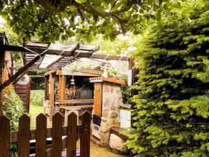 einen Holzzaun neben einem Steinofen im Garten in der Unterkunft Bungalow und Ferienwohnung auf Rügen in Kluis