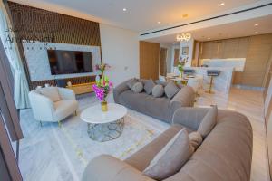 a living room with couches and a table and a television at Arabian Nights - Seaside Splendor Apartment at Atlantis The Royal in Dubai