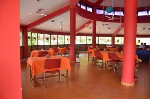 een eetkamer met oranje tafels en stoelen bij Indismart Woodbourne Resort in Madgaon