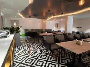 a restaurant with tables and chairs in a room at Hotel Kyzen Hi Tech City in Hyderabad