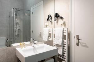 a bathroom with a white sink and a mirror at Living Lisboa Baixa Apartments in Lisbon +62 photos