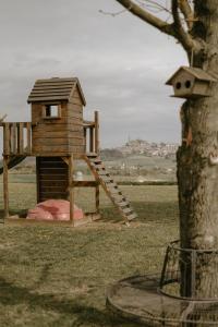 eine hölzerne Spielstruktur mit einer Treppe neben einem Baum in der Unterkunft Belcasale in Vignale