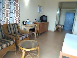 een woonkamer met een bank en een tafel bij Indismart Woodbourne Resort in Madgaon