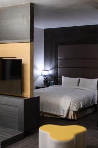 a bedroom with a large bed and a tv at Hotel Geight Taipei in Zhonghe