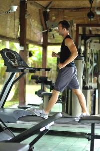 a man running on a treadmill in a gym at D'omah Yogya Hotel in Yogyakarta