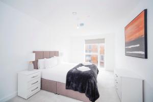 a white bedroom with a bed with a blanket on it at Modern 1Bed Apt with Parking - Grand Exchange Bracknell in Bracknell