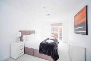 a white bedroom with a bed with a blanket on it at Modern Luxury - Grand Exchange Bracknell in Bracknell