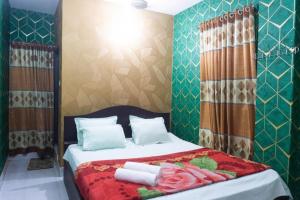 a bedroom with a bed with towels on it at Hotel Green Garden Residential Jatrabari in Dhaka