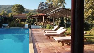 a group of lounge chairs next to a swimming pool at Kissos Apartments in Vourvourou