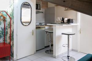 a kitchen with a bar with stools and a mirror at DIFY Dugas Montbel - Presqu ile in Lyon