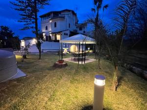 una casa con un patio iluminado por la noche en John Sea Suites en Giardini Naxos