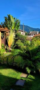 un grupo de palmeras frente a una casa en Pousada Shiva São Sebastião 200mts da praia en São Sebastião