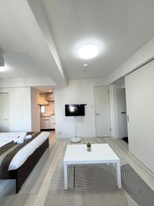 a bedroom with a bed and a table and a tv at REGNO COMFORT ASAKUSA Ⅳ in Tokyo