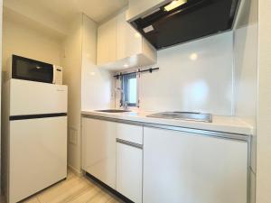 a small kitchen with a refrigerator and a sink at REGNO COMFORT ASAKUSA Ⅳ in Tokyo