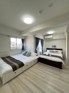 a bedroom with two beds and a window at REGNO COMFORT ASAKUSA Ⅳ in Tokyo