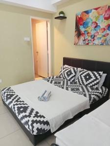 a bedroom with a bed with a black and white comforter at Caliph Suite Apartment Homestay D'Perdana Sri Cemerlang Condominium Kota Bharu in Kota Bharu